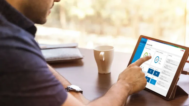 Bosch Installateur informiert sich am Tablett über das Klimahelden Schmiede Programm.