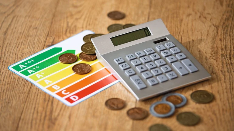 Auf dem Tisch liegen Ökodesign-Richtlinien ErP-Label mit einem Taschenrechner und Münzen