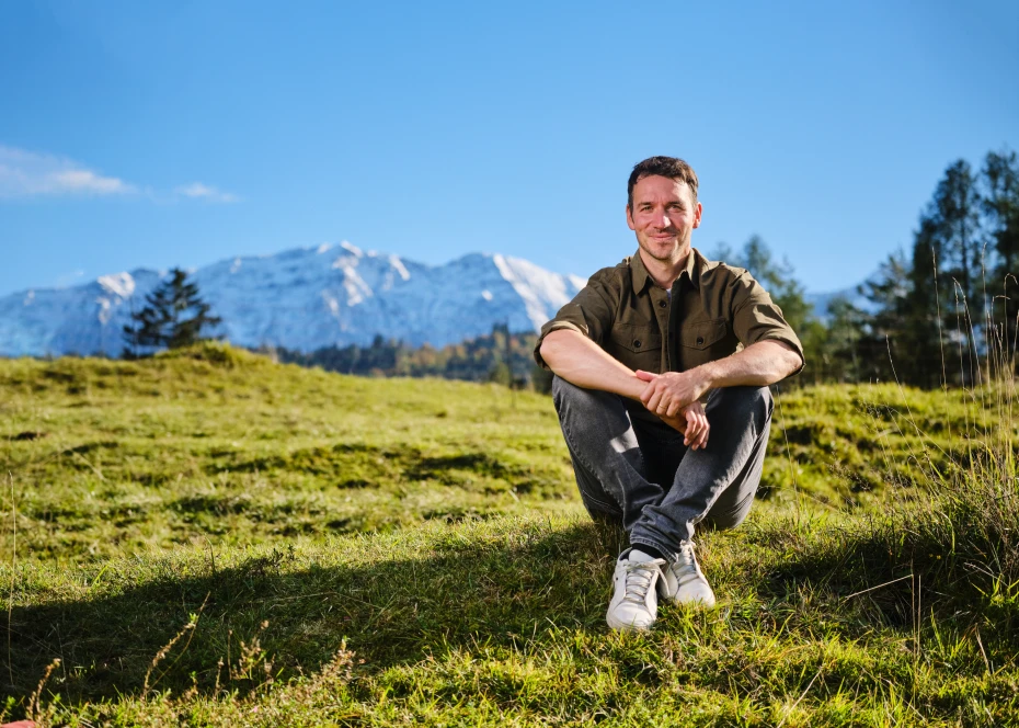 Felix Neureuther, der Skirennläufer steht vor einem Wald.