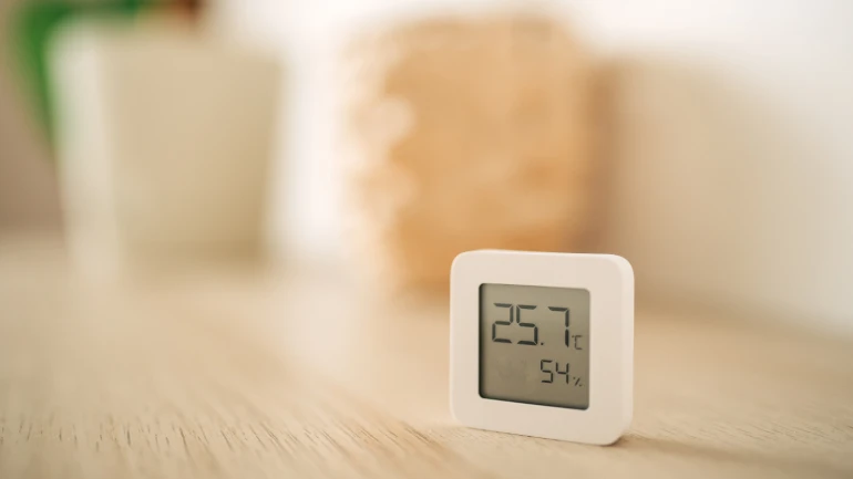 Feuchtigkeits- und Temperaturmessgerät auf einem Regal stehend.