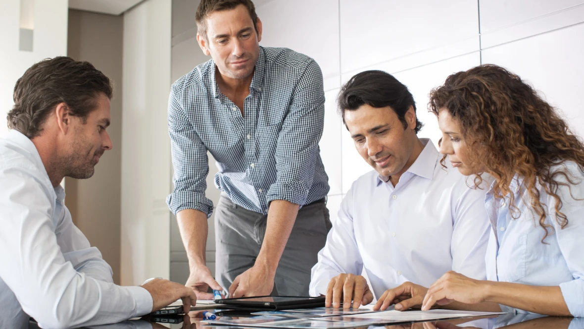 Gruppe von Personen diskutiert am Tisch die Genehmigung für den Einbau einer Klimaanlage