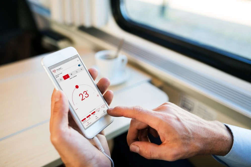 Mann im Zug bedient HomeCom Easy App.