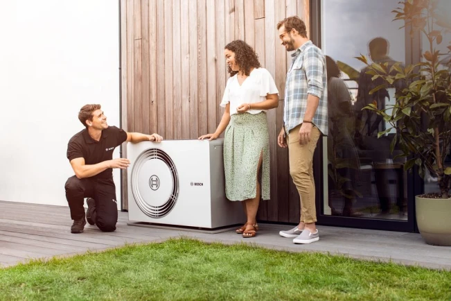 Bosch Installateur berät Kunden über die neu installierte Wärmepumpe.