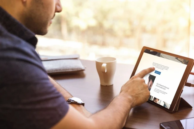Auf dem Tisch wird eine technische Zeichnung beschriftet, daneben befindet sich eine weiße Tastatur, ein Bleistift und ein Lineal