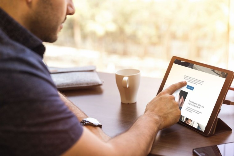 Ein Mann informiert sich am Tablet über das Jungmeister Programm. Ein Mann informiert sich am Tablet über das Jungmeister Programm.