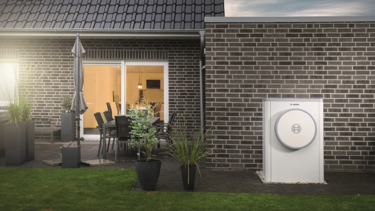 Modernes Backsteinhaus mit verbauter Compress 7400i AW im Garten