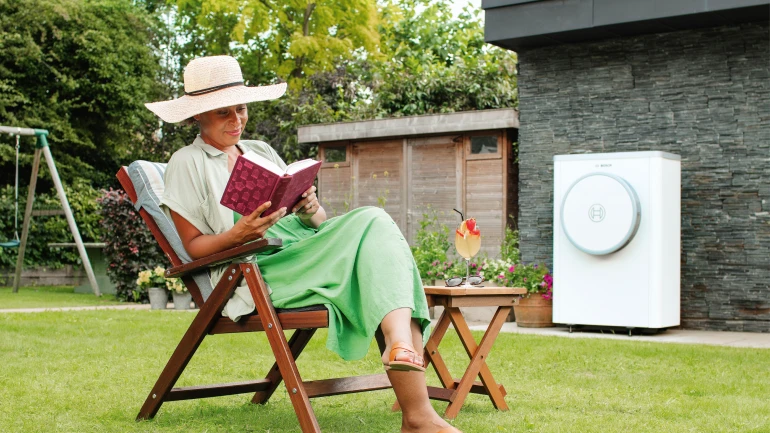 Frau sitzt in einem Gartenstuhl neben einer Compress 7400i AW