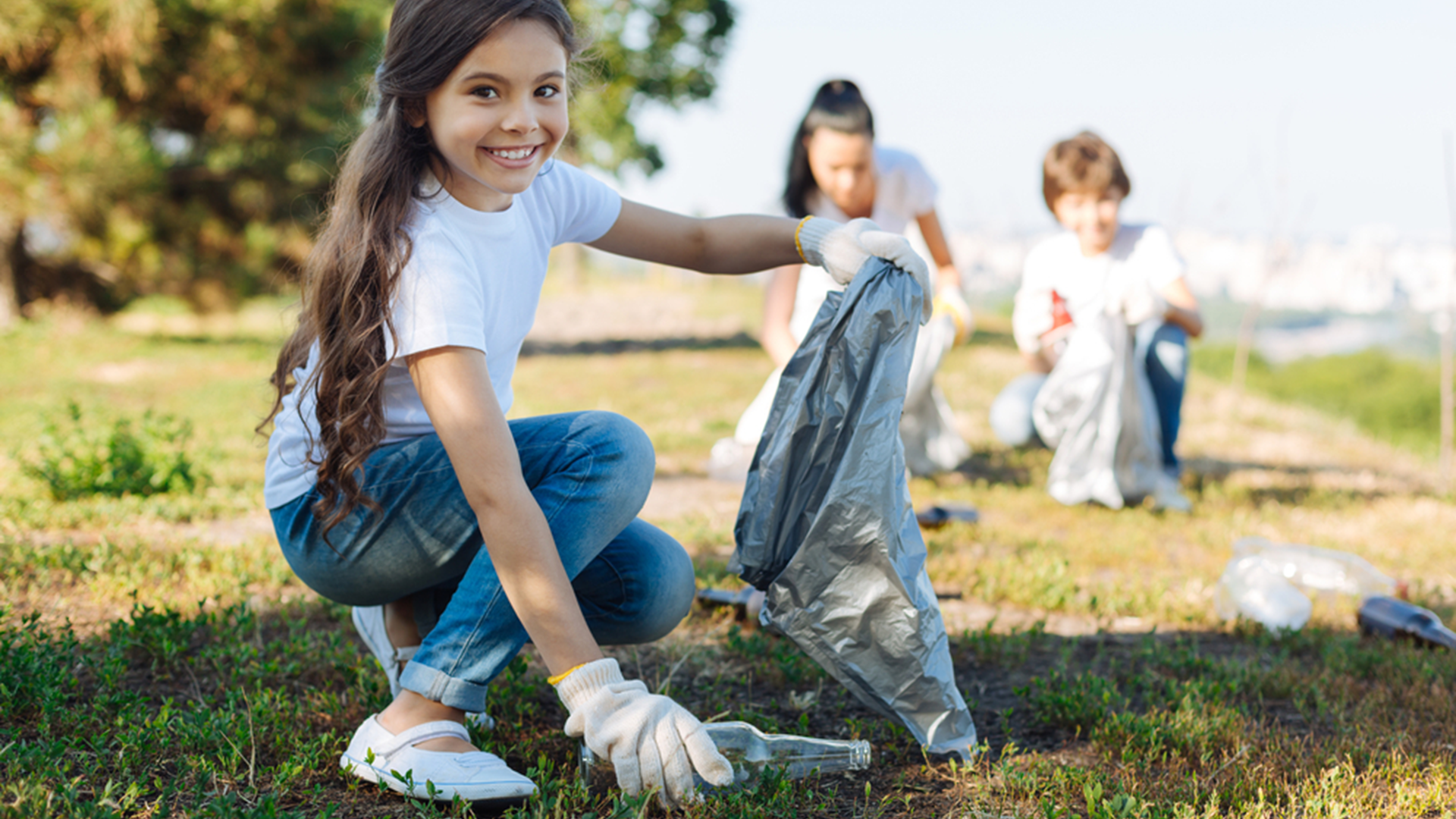 Ein Mädchen ist beim Müll trennen in der Natur.