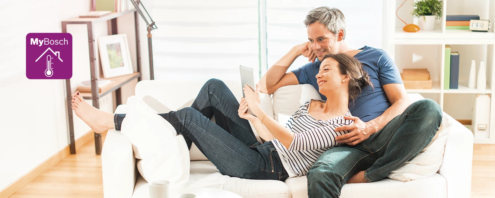 Frau mit Tablet in der Hand schaut mit ihrem Partner nach Informationen