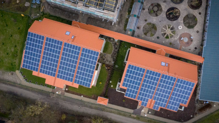 Blick von oben auf ein Hausdach mit Photovoltaikanlage