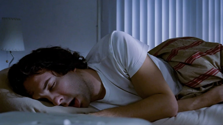 Schlafender und schnarchender Mann liegt im Bett.