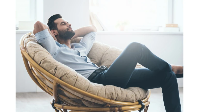 Ein junger Mann relaxt in einem Sessel.