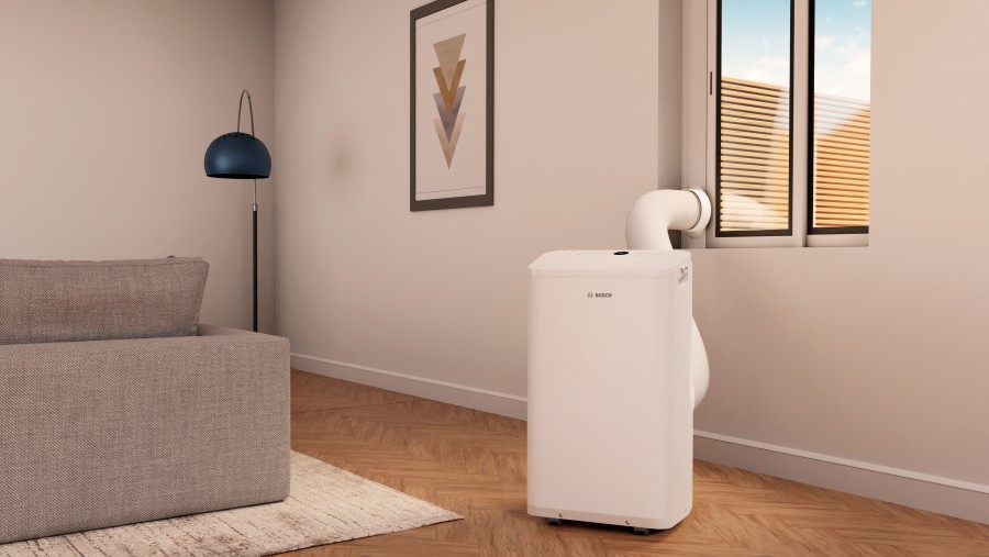 Mobile Klimaanlage an Fenster in Wohnzimmer stehend Mobile Klimaanlage an Fenster in Wohnzimmer stehend
