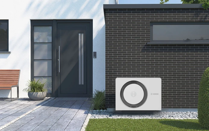 Bosch Wärmepumpe Compress 5800 6800i AW stehend vor einer Hauswand neben dem Eingang