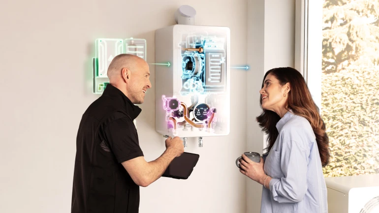 Ein Mann und eine Frau stehen vor einer geöffneten Gasheizung und unterhalten sich.