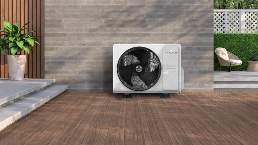 Ein Klimagerät steht an der Hauswand eines moderen Hauses. Ein Klimagerät steht an der Hauswand eines moderen Hauses.