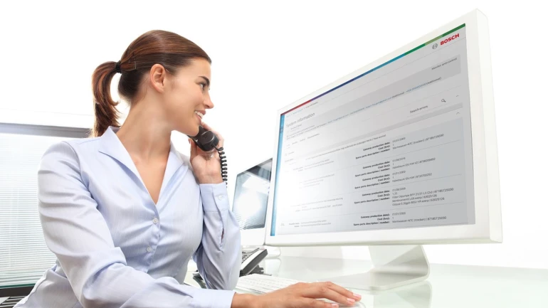 Frau von Bosch Kundenservice am Telefon und am Computer sitzend