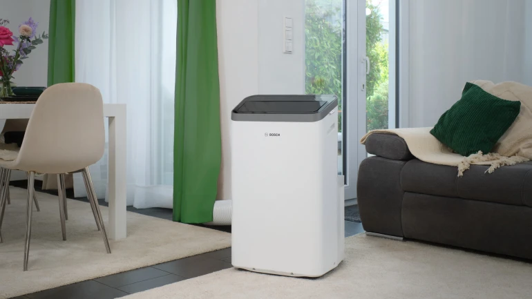 Ein mobiles Klimagerät von Bosch steht im Wohnzimmer.