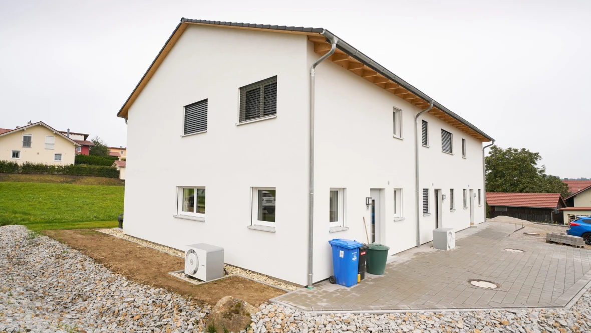 Bosch Compress 5800i AW vor Neubau Mehrfamilienhaus stehend