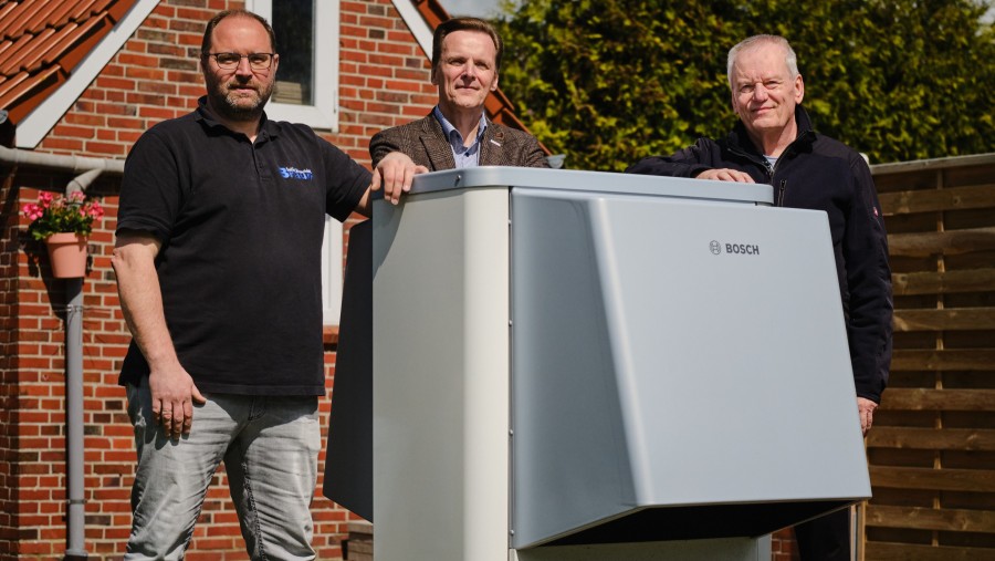 Installateure neben Wärmepumpe stehend. Installateure neben Wärmepumpe stehend.