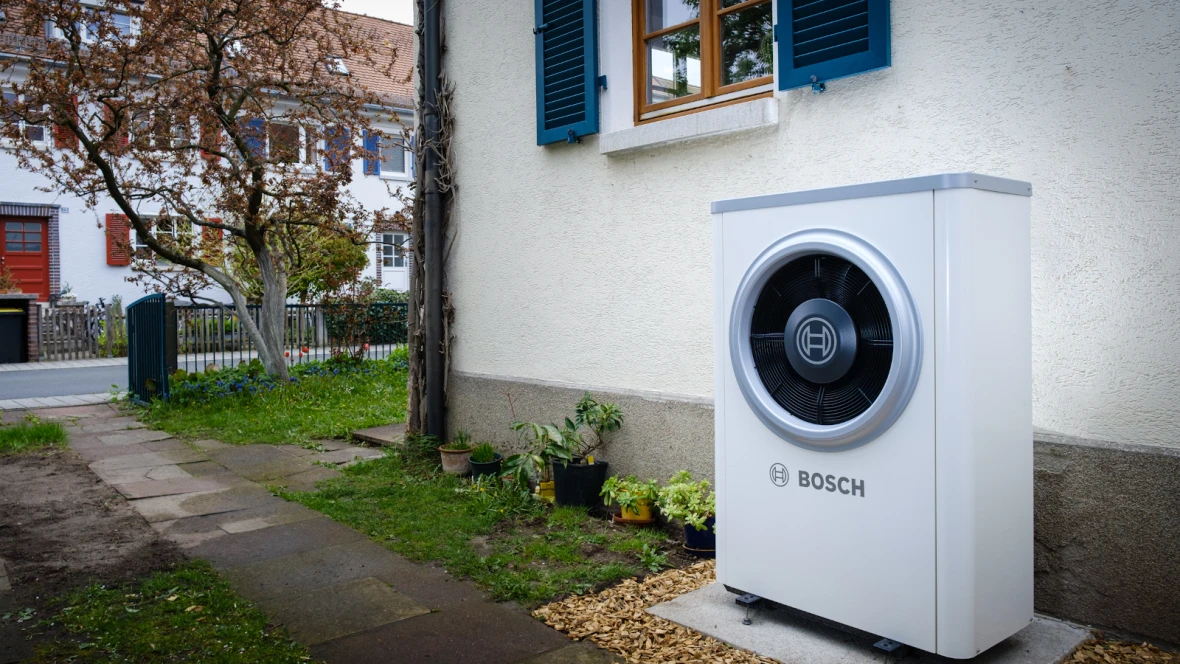 Bosch Wärmepumpe Compress 7400i AW vor Haus im Garten stehend