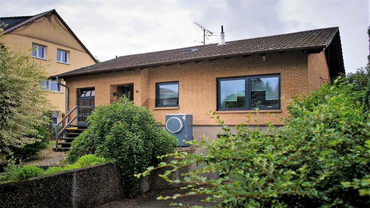 Backstein-Einfamilienhaus mit Gebüsch davor