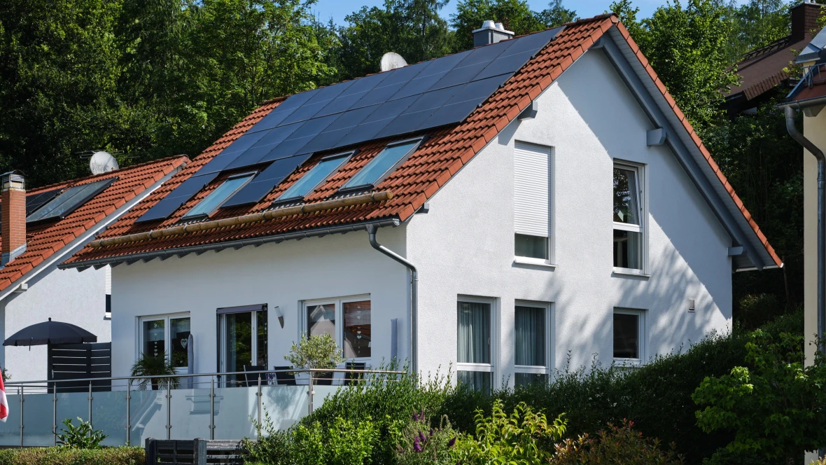 Ein weiß gestrichenes Haus mit Solarpaneelen auf dem Dach.