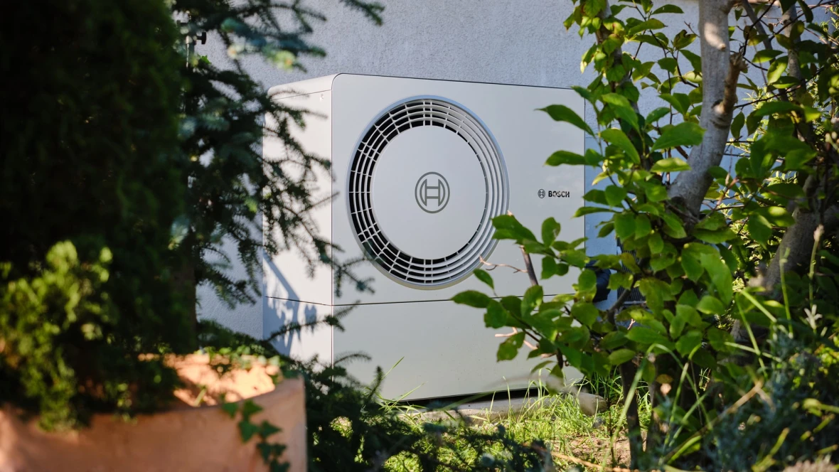Video Bosch Luft-Wasser-Wärmepumpe Compress 6800i AW steht auf einem Montagepodest mit Verkleidung vor einer Hauswand