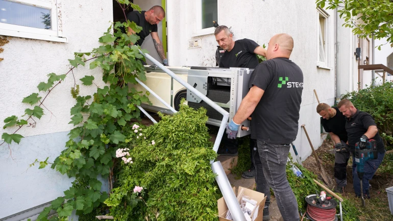 Installateure tragen Gerät aus Haus