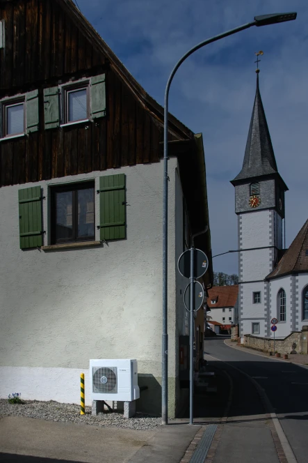 Altes Haus mit Kirchturm im Hintergrund
