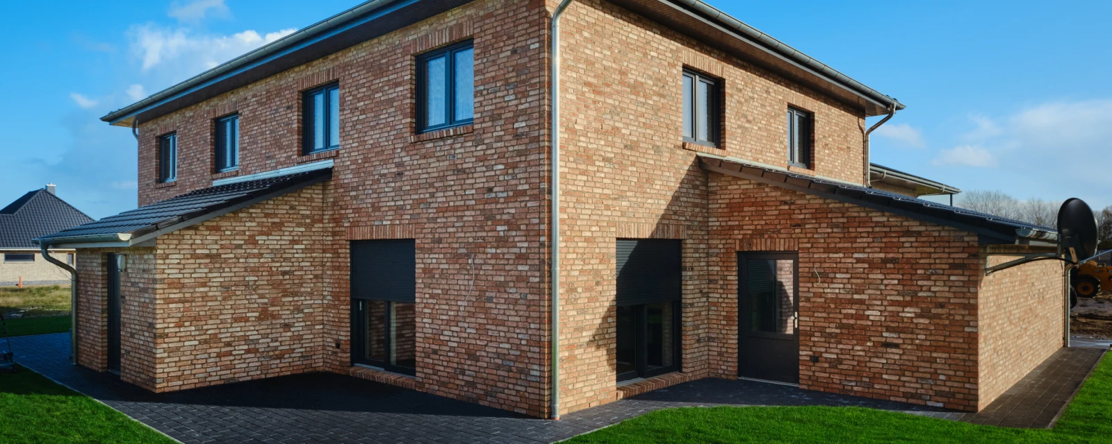 Ein Backsteinhaus mit einem großen Garten.