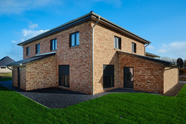 Ein modernes Backsteingebäude mit großem Garten.