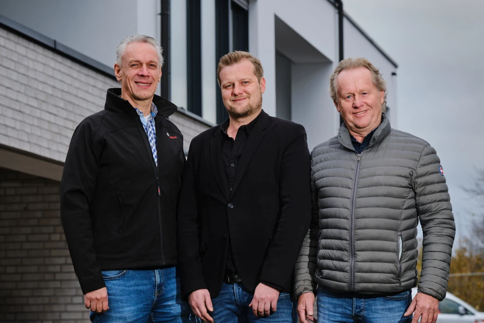 Drei Männer / Installateure schauen in die Kamera