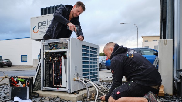 Zwei Männer arbeiten an Wärmepumpenmontage