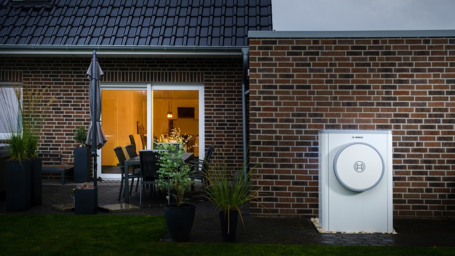 Modernes Backsteinhaus mit verbauter Wärmepumpe Compress 7400i AW im Garten.