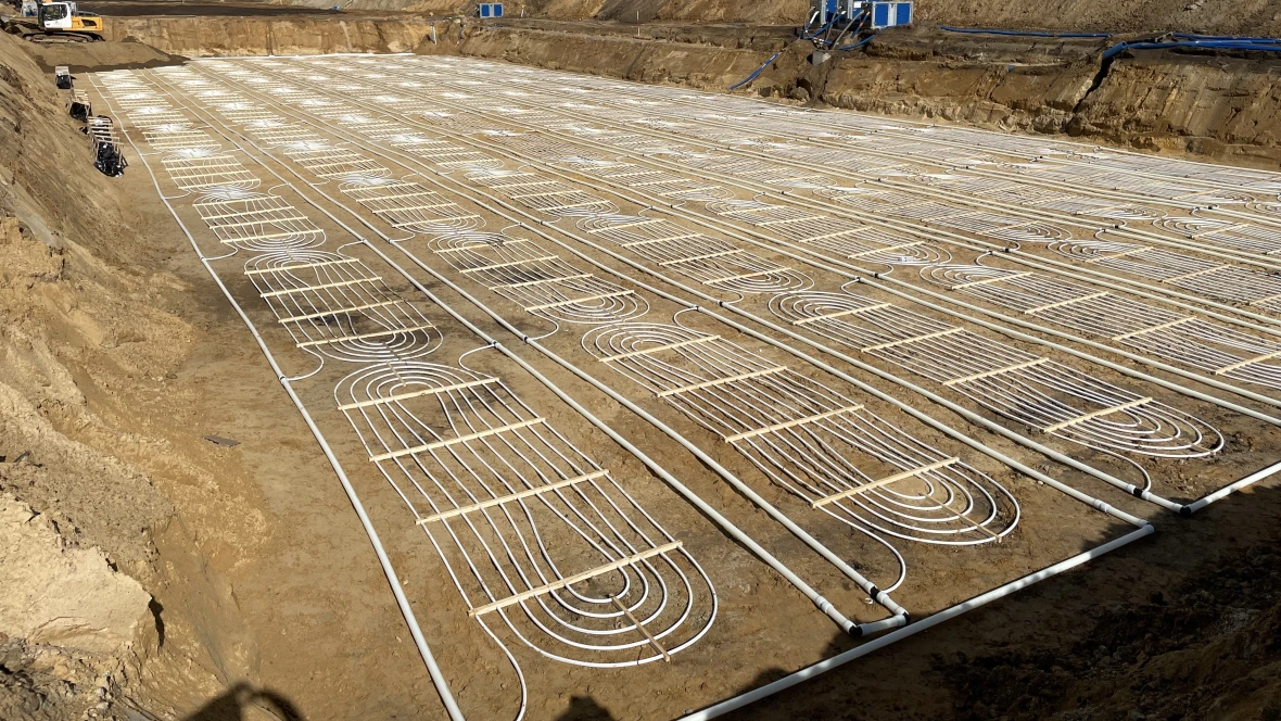 Die Wärmepumpe nutzt horizontal verlegte Kollektoren auf Flächen, um thermische Energie aus dem Boden zu gewinnen.