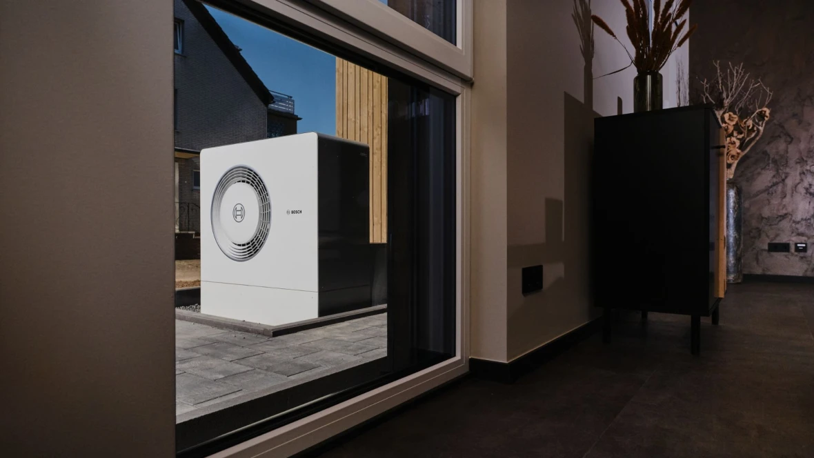 Wärmepumpe zu sehen durch ein Fenster.