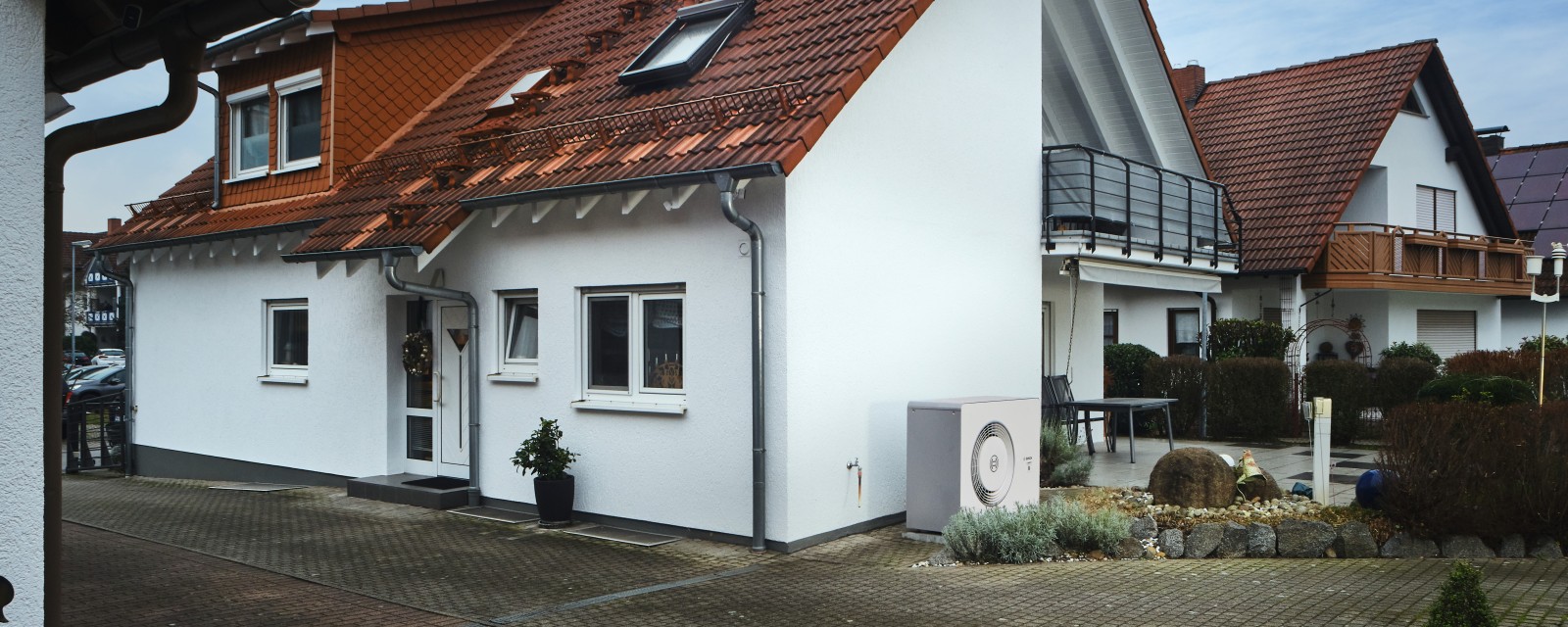 Bosch Wärmepumpe Compress 6800i AW steht an der Hauswand einer Doppelhaushälfte. Bosch Wärmepumpe Compress 6800i AW steht an der Hauswand einer Doppelhaushälfte.