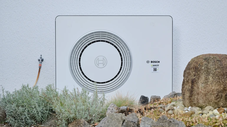 Bosch Wärmepumpe Compress 6800i AW steht an weißer Hauswand.