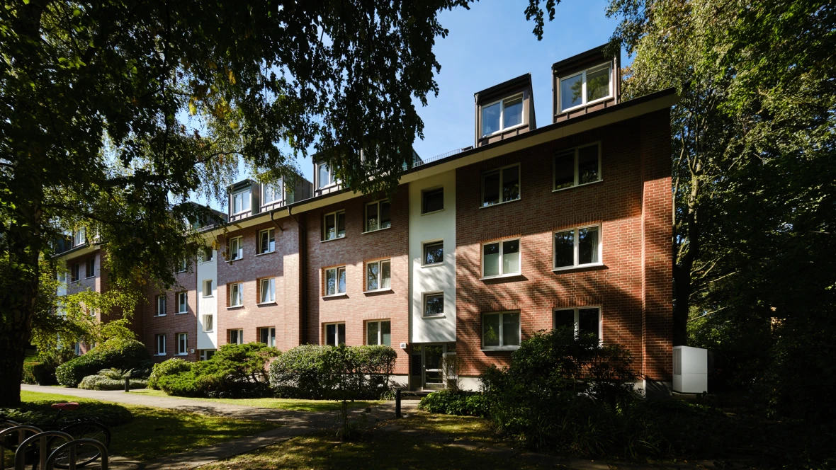 Mehrfamilienhaus mit alten Bäumen davor