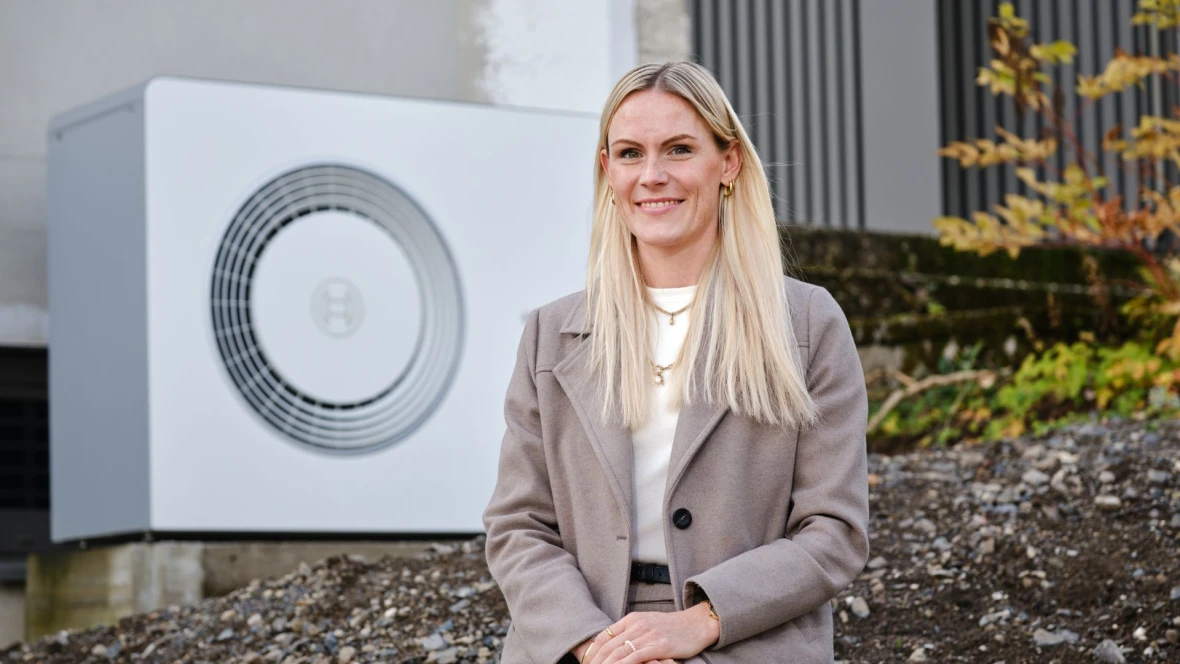 Bauherrin mit Wärmepumpe von Bosch im Hintergrund