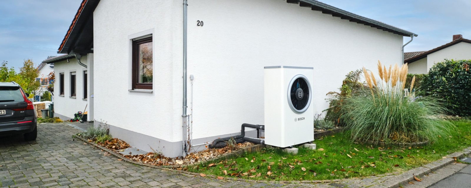 Bosch Wärmepumpe Compress 7000i AW an Hauswand eines Einfamilienhauses stehend. Bosch Wärmepumpe Compress 7000i AW an Hauswand eines Einfamilienhauses stehend.