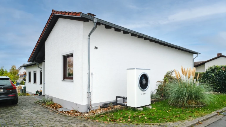 Bosch Wärmepumpe Compress 7000i AW vor Hauswand eines Einfamilienhauses stehend