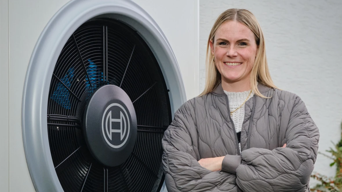 Frau mit verschränkten Armen vor Bosch Wärmepumpe Compress 7000i AW stehend