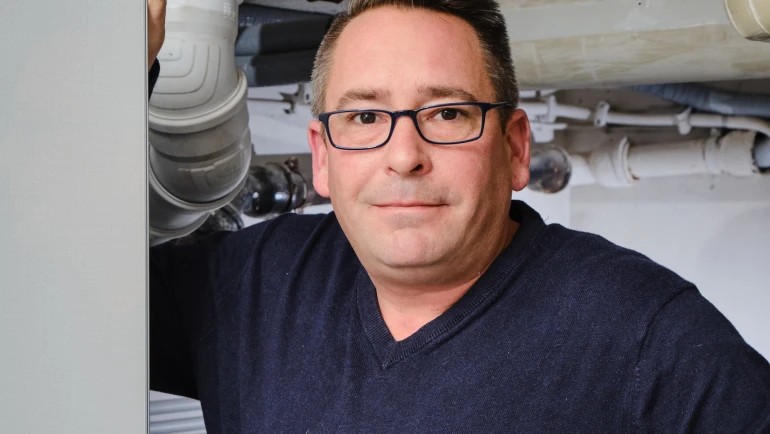 Mann lehnt an Bosch Wärmepumpe Compress 7000i AW