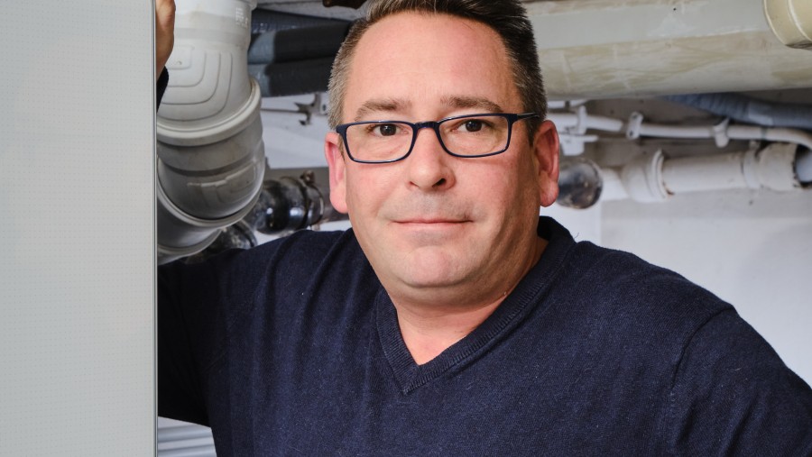 Mann lehnt an Bosch Wärmepumpe Compress 7000i AW Mann lehnt an Bosch Wärmepumpe Compress 7000i AW