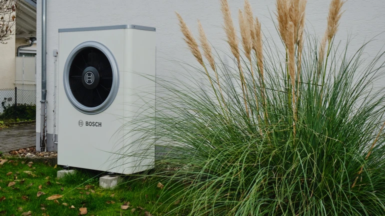 Bosch Wärmepumpe Compress 7000i AW neben Pampasgras vor Hauswand stehend