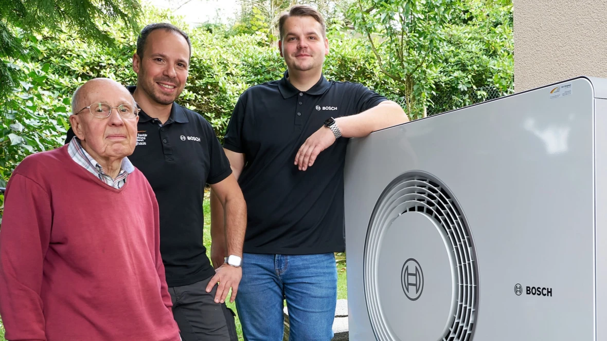 Bauherr mit Bosch-Installateuren vor Wärmepumpe