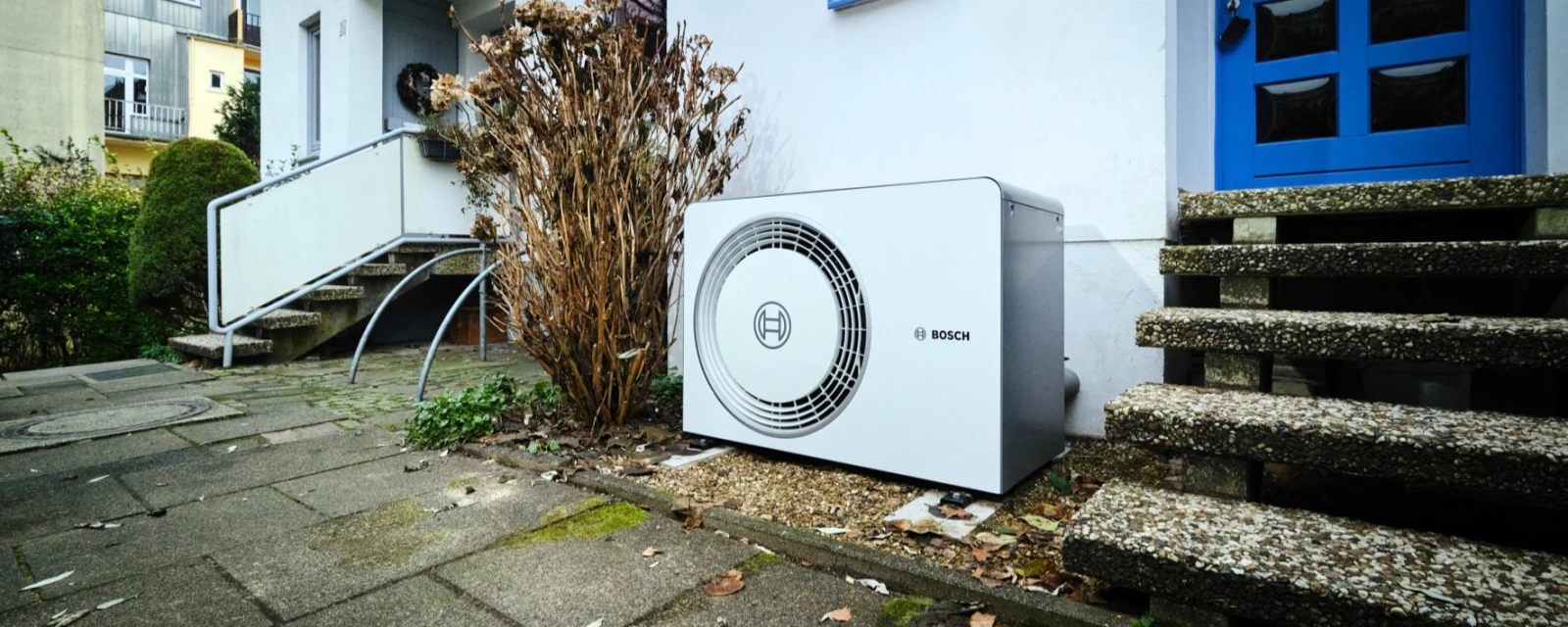 Wärmepumpe 6800i AW steht vor dem Haus neben dem Eingang.
