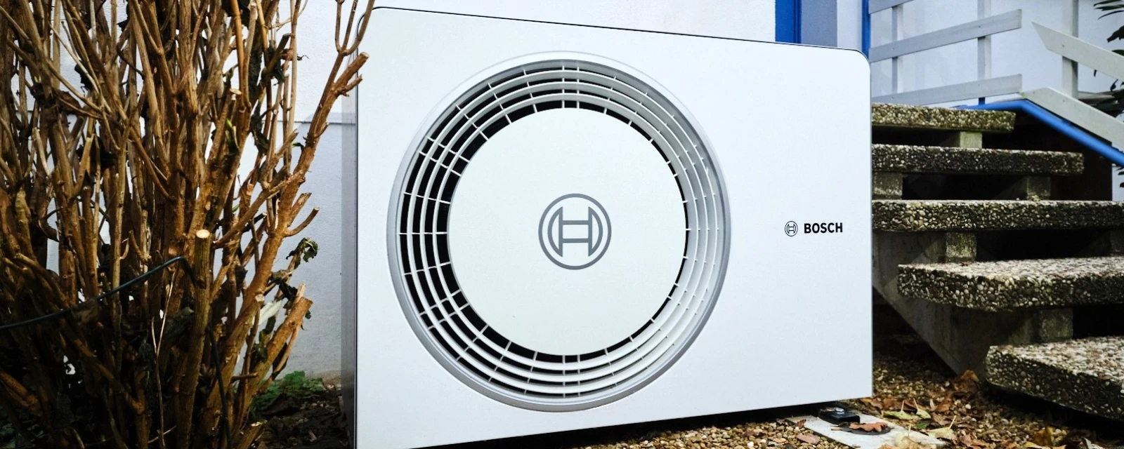 Bosch Luft-Wasser-Wärmepumpe Compress 6800i AW steht vor einem Haus in der kalten Jahreszeit